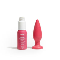 Set Dafne con lubrificante naturale Doride 50 ml e plug anale Holly 100% bio-based, entrambi in rosso magenta su sfondo bianco