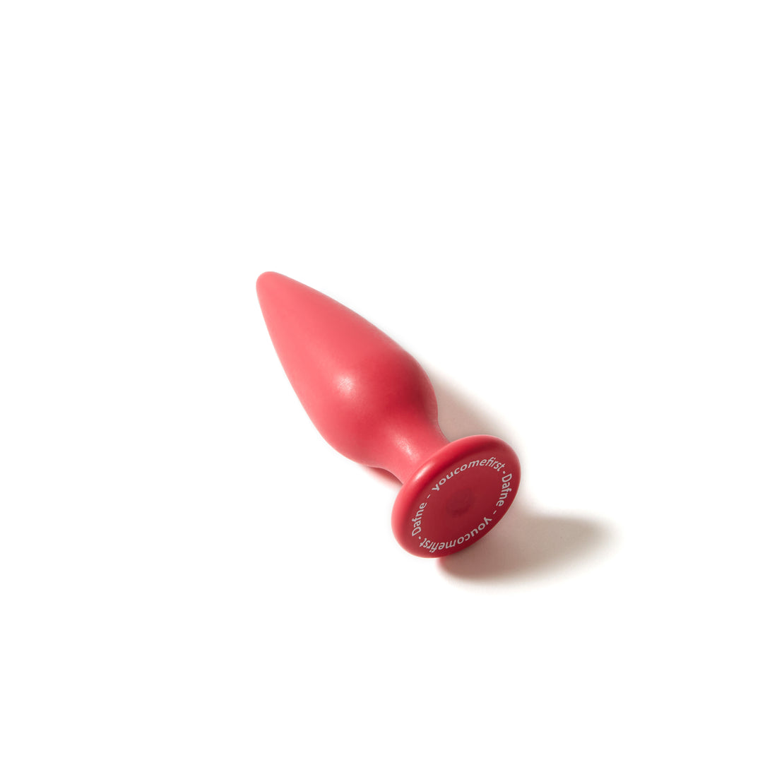 Plug anale Holly Dafne bio based rosso magenta, appoggiato su superficie bianca con base visibile e logo inciso