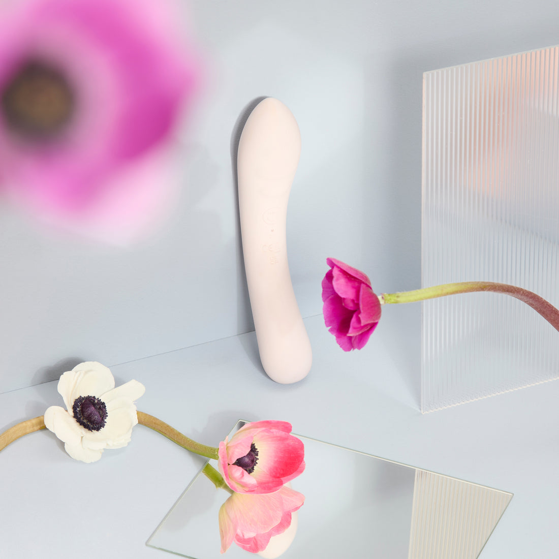 Vibratore in silicone nude Double Trouble, ambientato tra fiori e superfici riflettenti